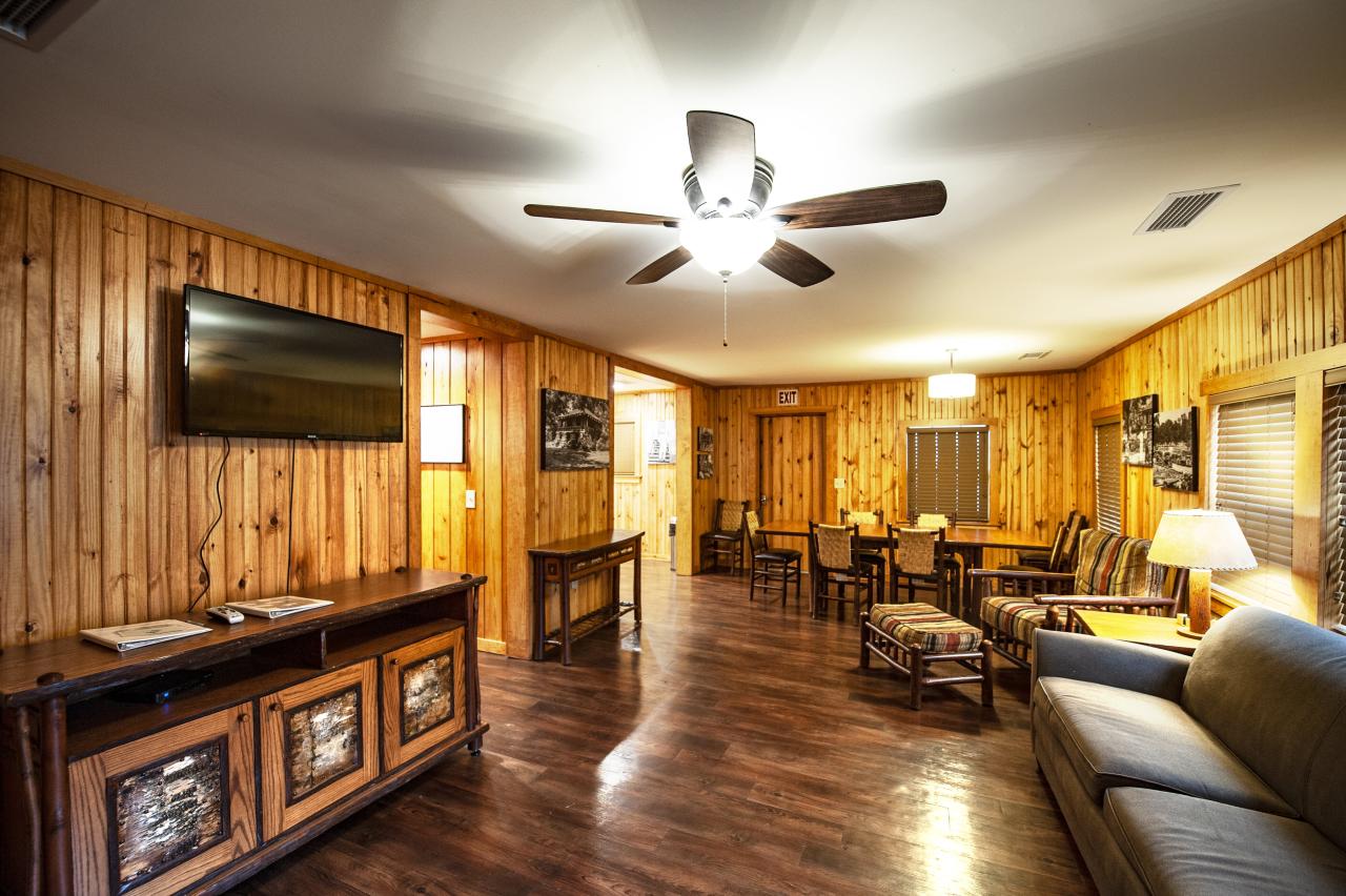 A view of the living room and dining area with siting area, tv and full dining table at the CCC cabin at Crowley's Ridge State Park
